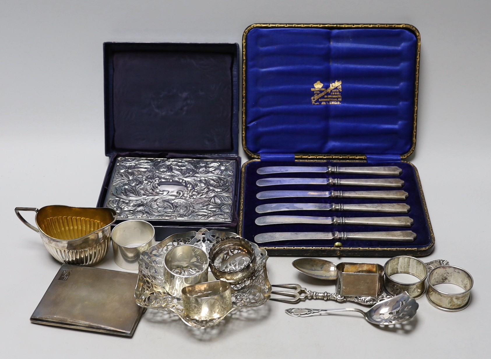 Sundry silver items including pierced shallow dish, cased handled tea knives, sterling mounted diary, cigarette case, seven napkin rings, cream jug and three items of cutlery.
